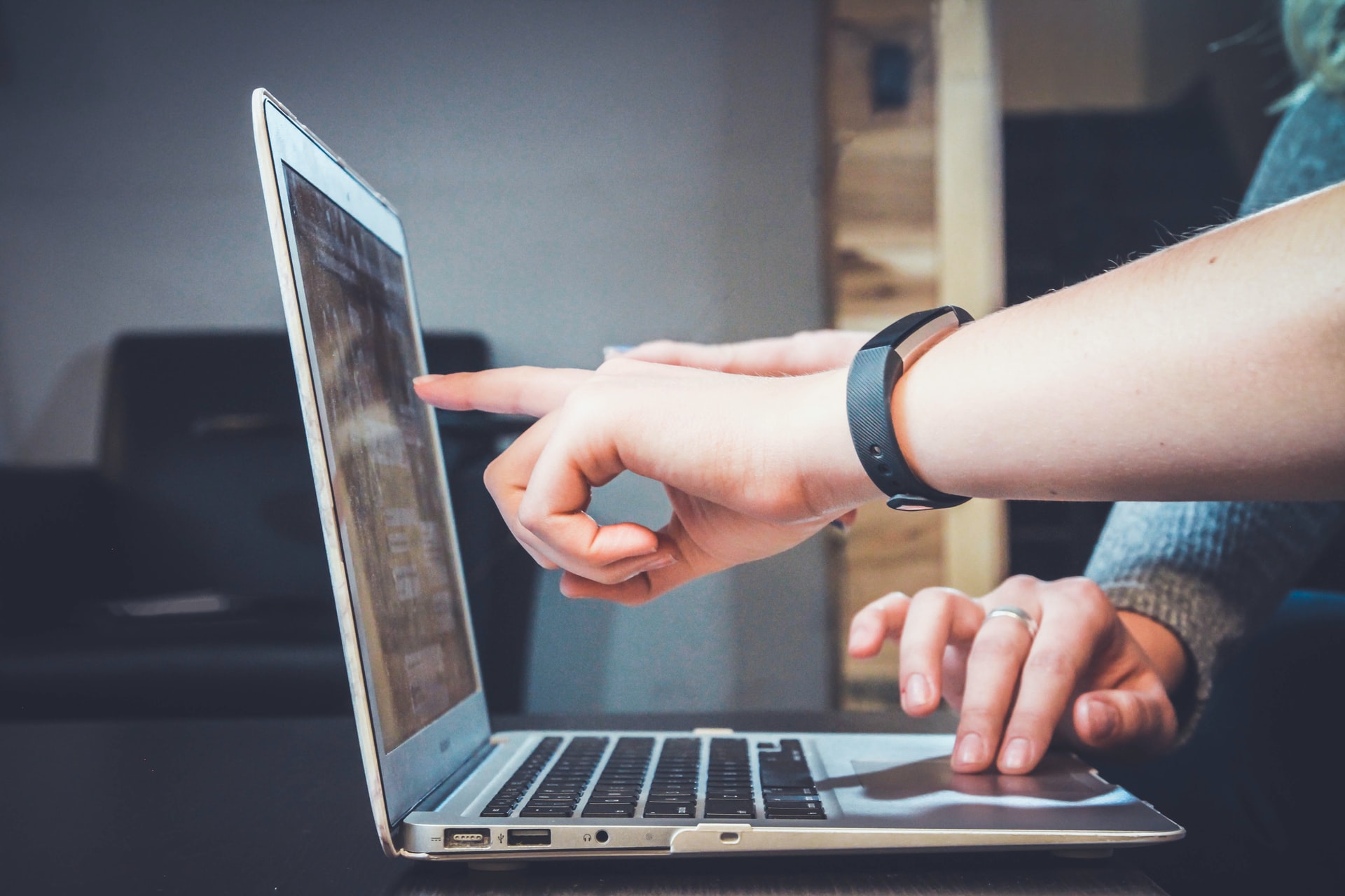 Zwei Personen besprechen Inhalte auf einem Laptop-Bildschirm